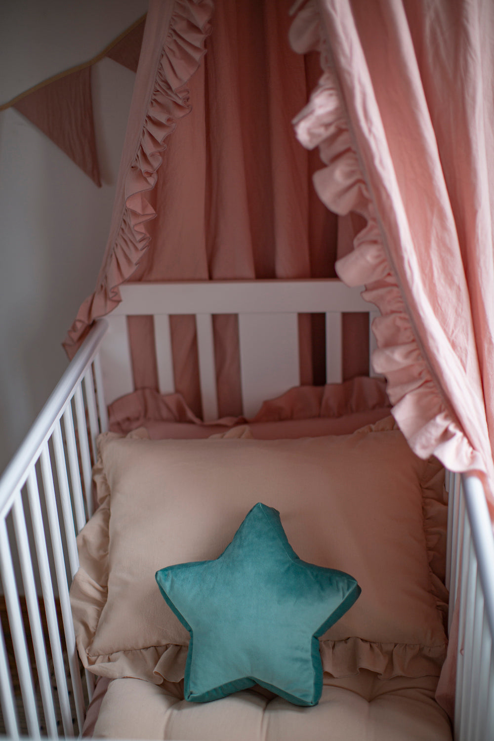 Mała poduszka gwiazdka welurowa miętowa od Bettys Home w dziecięcym łóżeczku nad którym wisi baldachim od Bettys Home