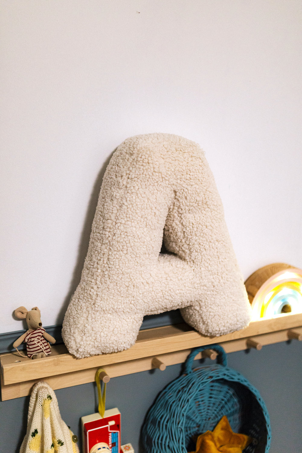 poduszka literka baranek A od Bettys Home która stoi na półce w pokoiku dziecka jako dekoracja 