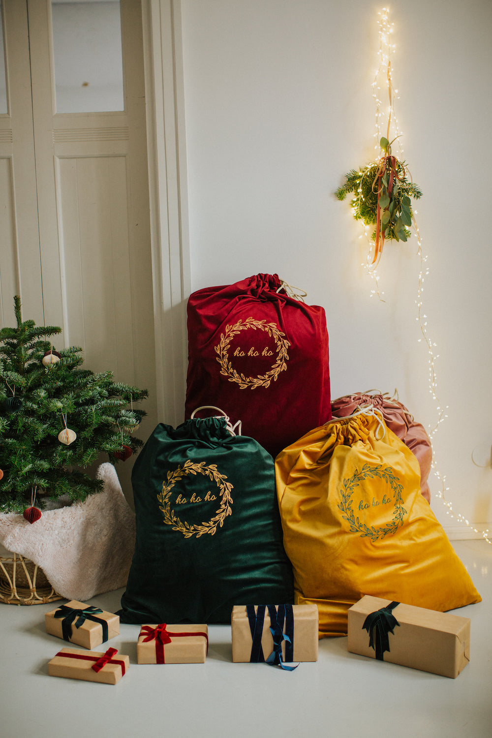 świąteczne worki na prezenty od Bettys Home z weluru z haftowanym napisem ho ho ho obok choinki