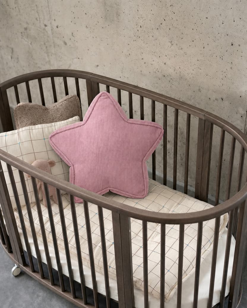 Różowa sztruksowa poduszka gwiazda w owalnym drewnianym łóżeczku na tle betonowej ściany - Bettys Home