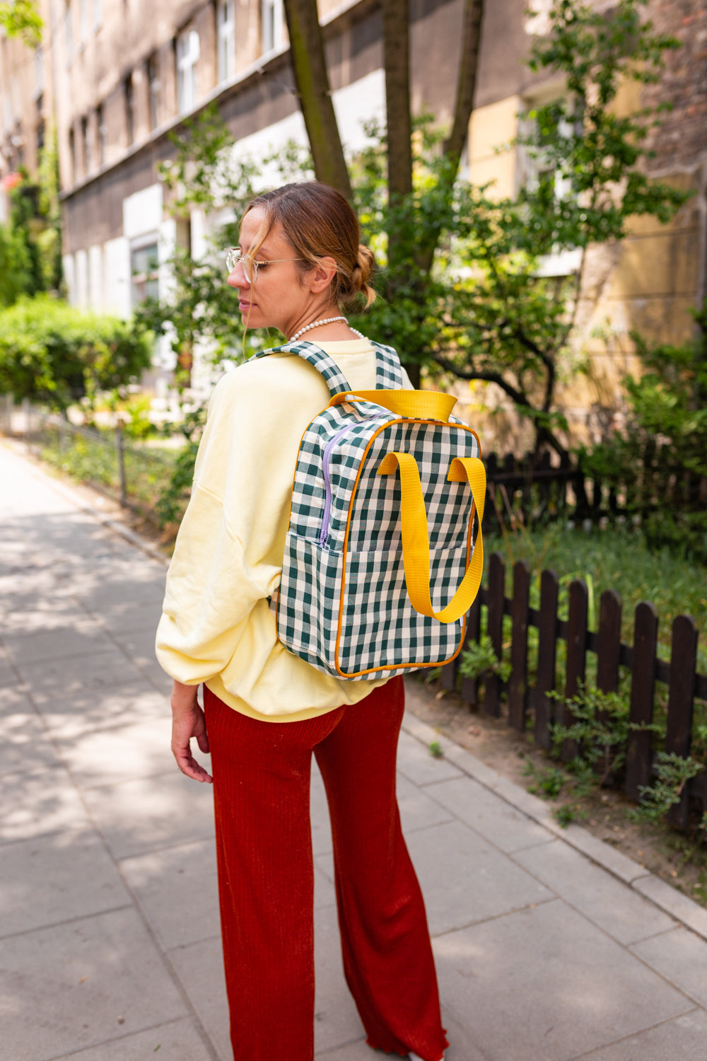 młoda kobieta w mieście z zielonym plecakiem w kratkę od Bettys Home, elegancki plecak na laptopa damski