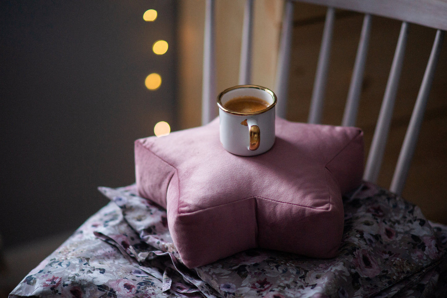 kubek z kawą stojący na małej poduszce gwiazdce różowej z weluru od bettys home. dekoracja salonu w skandynawskim stylu