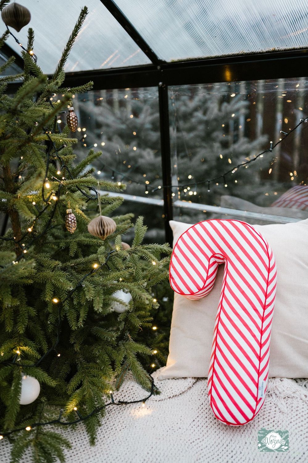 świąteczna poduszka laska w biało czerwone paski od Bettys Home dekoracja w szklarni na fotelu