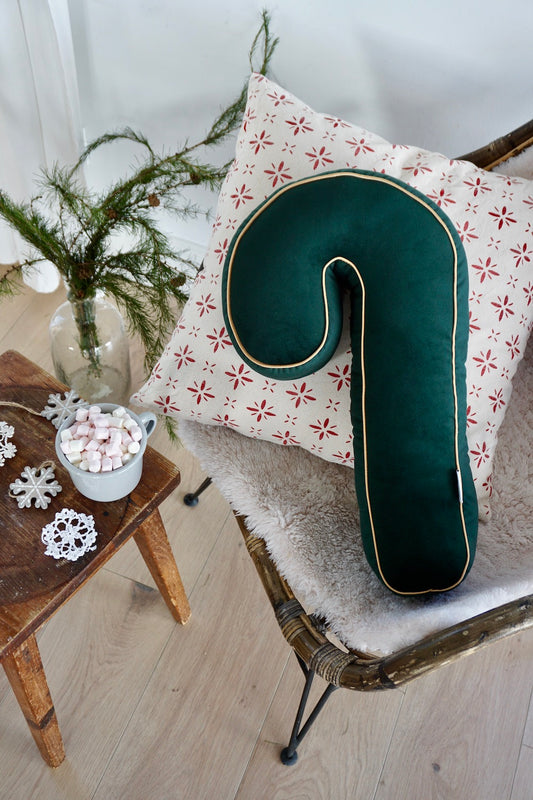 Świąteczna poduszka laska cukrowa zielona od Bettys Home leżąca na krześle jako dekoracja świąteczna