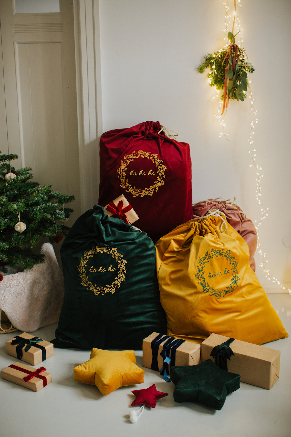 świąteczne worki na prezenty w trzech kolorach od Bettys Home obok choinki i prezentów