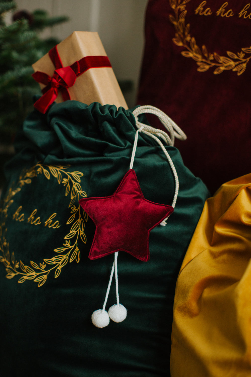 świąteczny worek na prezenty w kolorze zielonym i mała gwiazdka zawieszka w kolorze czerwonym